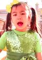Excited child wearing a sparkling green dress and bow, showcasing vibrant colors in a fun outdoor setting by Jannie Toys.