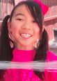 Happy girl with pigtails wearing a bright pink outfit and bow, smiling joyfully outdoors, capturing the essence of childhood.