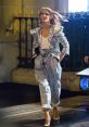 Celine Dion showcases a glamorous look in a sequined jacket and stylish pants, embodying elegance in her latest advert.