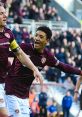 Heart of Midlothian FC players celebrate a goal, showcasing team spirit and passion for club songs and traditions.
