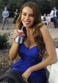 Woman in a blue dress smiles while enjoying a Diet Pepsi at a social event, showcasing a refreshing and stylish moment.