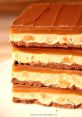Delicious layered Snicker dessert featuring rich chocolate, creamy nougat, and caramel, perfect for sweet cravings.