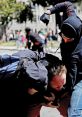 Two individuals engage in a physical altercation, highlighting a moment of conflict and intense struggle in an urban setting.