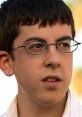 McLovin character from Superbad, wearing glasses, sporting a serious expression in a casual setting.