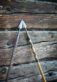Two intricately designed Dzida spears with decorative grips against a rustic wooden background showcase traditional craftsmanship.