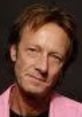 Dave Donkervoort smiling, showcasing his signature style and charm, embodying creativity and innovation in his work.