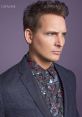 Stylish male model in a floral shirt and blazer, showcasing modern fashion trends and sophisticated style.