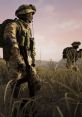 Soldiers in tactical gear navigate through tall grass, showcasing teamwork and readiness in a military squad setting.