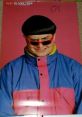 Oliver Tree poses with a playful expression, wearing stylish shades and a colorful jacket, embodying pop culture vibes.