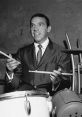 uddy Dense playing drums, showcasing his talent and style in a vintage black and white setting.