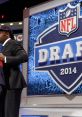 Player on stage excited during the 2014 NFL Draft, celebrating a significant career milestone in professional football.