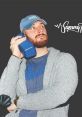 Sammy K styled in casual attire, holding a blue speaker, exuding a cool and relaxed vibe. Perfect for music lovers.