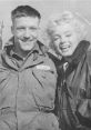 Marilyn Monroe smiling with a soldier, capturing a moment of joy and camaraderie during her time in the military.