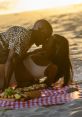 Couple sharing a romantic moment on the beach during sunset, surrounded by a picnic setup, embodying "Too Hot To Handle" vibes.