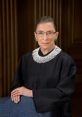 Ruth Bader Ginsburg in judicial robes, showcasing her iconic collar and poised expression in a formal setting.