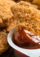 Crispy chicken nugget dipped in savory sauce, highlighting a delicious snack option for all ages. Perfect for sharing!
