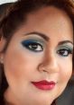 Aila showcasing stunning makeup with bold blue eyeshadow and vibrant red lips, radiating confidence and beauty.