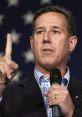 Rick Santorum passionately addresses an audience, emphasizing key points while holding a microphone against a star backdrop.