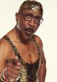 Confident man in a gold-patterned outfit and glasses, pointing assertively, exudes charisma and determination.