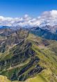 Breathtaking view of Monte peaks, showcasing lush greenery and dramatic mountain ranges under a clear blue sky.