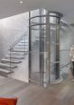 Modern glass elevator adjacent to stylish staircase, showcasing contemporary interior design and accessibility features.