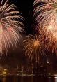 Bright fireworks illuminate the night sky over a bustling city skyline, showcasing vibrant colors and festive patterns.