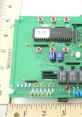 Bard Board circuit with components, including MC3000 chip and capacitors, displayed alongside a ruler for size reference.