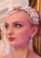 Elegant debutante showcasing a sophisticated hairstyle adorned with a pearl headpiece and sparkling earrings.