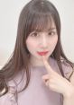 八木沙季が指を口元に当ててポーズをとる可愛らしい表情、軽やかなファッションの一コマ。