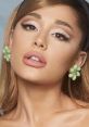 Close-up of Ariana Grande showcasing stunning makeup and stylish green floral earrings, highlighting her iconic beauty.