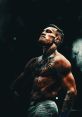 Conor McGregor showcasing fierce determination in the octagon, highlighted by his striking tattoos and intense expression.