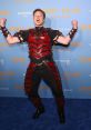 Elon Musk celebrating Halloween in a bold red and black armor costume at Heidi Klum's annual party event.