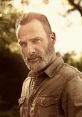 Rick Grimes with a rugged beard and intense gaze, surrounded by a natural backdrop, conveying strength and leadership.