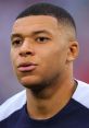 Kylian Mbappé focused before a match, showcasing his determination and competitive spirit on the soccer field.
