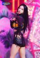 Karina showcases her vibrant style and strong stage presence in a captivating performance setting with bright colors and dynamic lights.
