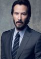 Keanu Reeves in a stylish suit, showcasing a charismatic and serious expression against a textured background.