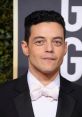 Rami Malek at the Golden Globe Awards, showcasing a stylish tuxedo with a bow tie, exuding elegance and charm.