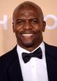 Terry Crews smiling at a red carpet event, wearing a classic tuxedo with a bow tie, exuding charm and confidence.