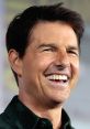 Tom Cruise smiles broadly at a promotional event, showcasing his trademark charisma and youthful energy.