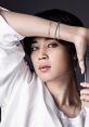 Jimin poses stylishly, showcasing his captivating piercing gaze and trendy accessories, embodying modern K-pop aesthetics.