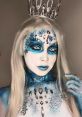 Enchanting blue-themed beauty look with intricate makeup and sparkling gems, showcasing creativity and artistic expression.
