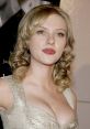 Scarlett Johansson at a red carpet event, showcasing her glamorous look with elegant curls and a stunning dress.