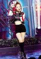 Jennie performs on stage in a stylish outfit, showcasing her dance skills and pop artistry in an energetic performance.