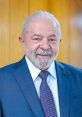 Luiz Inácio Lula Da Silva smiling, wearing a blue suit and tie, against a wooden background, showcasing his leadership presence.
