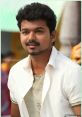 Vijay smiles confidently, showcasing his signature style in a casual outfit, capturing the essence of Tamil cinema charisma.