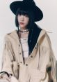 Hong Eunchae of LE SSERAFIM, showcasing chic style with a fringed jacket and black hat, exudes K-pop elegance and charisma.