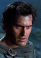 Ashley J. Williams looks intense with battle scars, showcasing his struggle against evil forces in a dark scene.