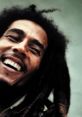 Bob Marley smiling broadly, showcasing his iconic dreadlocks against a soft background, embodying reggae culture and joy.