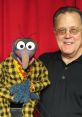 David Goelz alongside Gonzo, the iconic Muppet, showcasing their playful bond and colorful outfits.