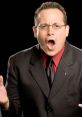 Joey Styles in a black suit and red shirt, passionately delivering commentary with an expressive gesture.